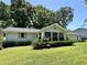 Rear view of a light-colored single-story home with a well-maintained lawn and mature landscaping at 8239 Sw 108Th St, Ocala, FL 34481