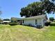 View of the house showing siding, windows and the air conditioning unit with well-kept lawn at 8239 Sw 108Th St, Ocala, FL 34481