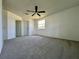 Bright bedroom with neutral carpet, a ceiling fan, and a large window at 8239 Sw 108Th St, Ocala, FL 34481