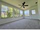 Bright sunroom with large windows offering views of the landscaped yard, and a ceiling fan at 8239 Sw 108Th St, Ocala, FL 34481