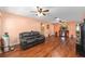 Open living room featuring laminate flooring, a ceiling fan, and a leather sofa at 9661 Sw 95Th Ct # B, Ocala, FL 34481