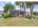 Landscaped backyard with mature palm trees and a screened porch at 9663 Sw 92Nd Place Rd, Ocala, FL 34481