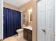 Cozy bathroom featuring a single vanity and shower with blue curtain at 9663 Sw 92Nd Place Rd, Ocala, FL 34481