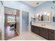 Bathroom featuring a double vanity, tiled floor, with a view into the Primary bedroom at 9663 Sw 92Nd Place Rd, Ocala, FL 34481