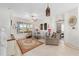 Bright living room featuring neutral walls, comfortable seating, and a large window overlooking the landscaped yard at 9663 Sw 92Nd Place Rd, Ocala, FL 34481