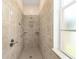 Tiled walk-in shower with a rainfall showerhead and convenient shelving at 9663 Sw 92Nd Place Rd, Ocala, FL 34481
