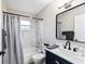 Updated bathroom features a tub shower, marble-look tile, and a black framed mirror over the vanity at 9729 Sw 97Th St, Ocala, FL 34481