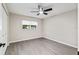 Spacious bedroom with modern gray flooring, a ceiling fan, and a window providing natural light at 9729 Sw 97Th St, Ocala, FL 34481