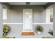 Close-up of the front door, featuring a decorative welcome mat and potted plants at 9729 Sw 97Th St, Ocala, FL 34481