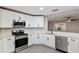 Modern kitchen with stainless steel appliances, white cabinets, and breakfast bar area at 9729 Sw 97Th St, Ocala, FL 34481
