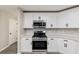 Well-lit kitchen features stainless steel appliances, and sleek white cabinets at 9729 Sw 97Th St, Ocala, FL 34481