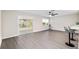 Open living area with gray vinyl floors, ceiling fan, and access to a sunroom at 9729 Sw 97Th St, Ocala, FL 34481