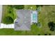 Aerial view of a private home with a screened-in pool and paved driveway, surrounded by greenery at 11140 Sw 53Rd Cir, Ocala, FL 34476