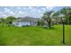 Spacious backyard featuring green grass, mature palm trees, and a screened-in patio area attached to the home at 11140 Sw 53Rd Cir, Ocala, FL 34476