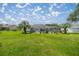 A lush backyard with green grass, palm trees, and a screened enclosure around the pool area at 11140 Sw 53Rd Cir, Ocala, FL 34476