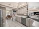Bright kitchen with white cabinets, tile flooring, and stainless steel appliances open to dining area at 11140 Sw 53Rd Cir, Ocala, FL 34476