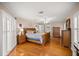 Large main bedroom with hardwood floors, shuttered windows and a ceiling fan at 11140 Sw 53Rd Cir, Ocala, FL 34476