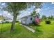 An outbuilding or shed with a small walkway and an American flag in a spacious backyard at 11140 Sw 53Rd Cir, Ocala, FL 34476