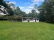 Expansive backyard featuring lush green lawn and mature trees surrounding the home at 11230 Se 47Th Ave, Belleview, FL 34420