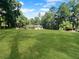 Beautiful, expansive backyard with lush lawn and trees on a sunny day at 11230 Se 47Th Ave, Belleview, FL 34420