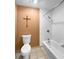 Bathroom featuring a toilet, bathtub with shower, tiled walls and a unique wall decor at 11230 Se 47Th Ave, Belleview, FL 34420