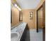 Bathroom featuring double sinks with marble counters, tile floors, and a decorative mirror at 11230 Se 47Th Ave, Belleview, FL 34420