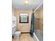 Functional bathroom featuring a shower-tub combination, a toilet and a window at 11230 Se 47Th Ave, Belleview, FL 34420