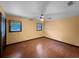 Bedroom featuring hardwood floors, two windows, ceiling fan, and neutral colored walls at 11230 Se 47Th Ave, Belleview, FL 34420