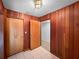 Wood-paneled hallway with three doors, tile flooring, and overhead lighting at 11230 Se 47Th Ave, Belleview, FL 34420