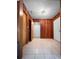 Hallway showcasing wood paneling, tile floors and access to multiple rooms at 11230 Se 47Th Ave, Belleview, FL 34420