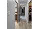 Hallway with wood flooring, neutral paint, and doors leading to various rooms and closets at 11230 Se 47Th Ave, Belleview, FL 34420