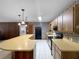 Galley kitchen featuring ample wood cabinetry, mosaic backsplash, and tiled floors at 11230 Se 47Th Ave, Belleview, FL 34420