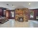 Inviting living room with stone fireplace, wood paneling, and lots of natural light at 11230 Se 47Th Ave, Belleview, FL 34420