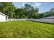 Spacious backyard with a lush green lawn and a pristine white vinyl privacy fence at 13314 Se 41St Ct, Belleview, FL 34420