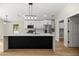 Modern kitchen with white cabinets, quartz countertops, and a stylish black island at 13314 Se 41St Ct, Belleview, FL 34420