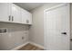An ample laundry room with white cabinets and wood flooring at 13314 Se 41St Ct, Belleview, FL 34420