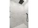 Luxurious shower with marble-style tiling and a sleek, modern showerhead at 13314 Se 41St Ct, Belleview, FL 34420