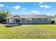 Exterior view of the home showing the expansive yard, patio, and siding at 1404 Se 40Th Ct, Ocala, FL 34471