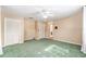 Bedroom featuring green carpet, white ceiling fan, and two closets at 1404 Se 40Th Ct, Ocala, FL 34471