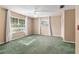Spacious bedroom featuring green carpet, two windows, and white curtains at 1404 Se 40Th Ct, Ocala, FL 34471
