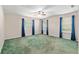 Spacious bedroom with ceiling fan, three windows letting in ample natural light and green carpet at 1404 Se 40Th Ct, Ocala, FL 34471