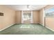 Bedroom featuring green carpet, large window, and white curtain at 1404 Se 40Th Ct, Ocala, FL 34471
