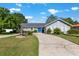 Charming home featuring a fountain, driveway, landscaping, and inviting blue front door at 1404 Se 40Th Ct, Ocala, FL 34471