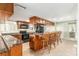 Traditional kitchen features wood cabinets, granite counters, black appliances, and a breakfast bar with seating at 1404 Se 40Th Ct, Ocala, FL 34471