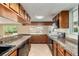 Traditional kitchen with wood cabinets, granite countertops, and black appliances at 1404 Se 40Th Ct, Ocala, FL 34471
