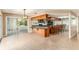 Well-lit kitchen with wood cabinets, granite countertops, bar seating, and an adjacent sunroom area at 1404 Se 40Th Ct, Ocala, FL 34471