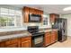 Traditional kitchen with wood cabinets, granite countertops, and black appliances at 1404 Se 40Th Ct, Ocala, FL 34471