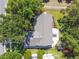 Aerial shot showcasing the home's roof, backyard, and patio surrounded by mature trees at 15917 Hidden Lake Cir, Clermont, FL 34711