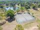 Aerial shot showcasing a well-maintained tennis court and mature trees at 15917 Hidden Lake Cir, Clermont, FL 34711