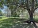 Spacious backyard featuring lush green grass and mature trees overlooking a serene lake at 15917 Hidden Lake Cir, Clermont, FL 34711